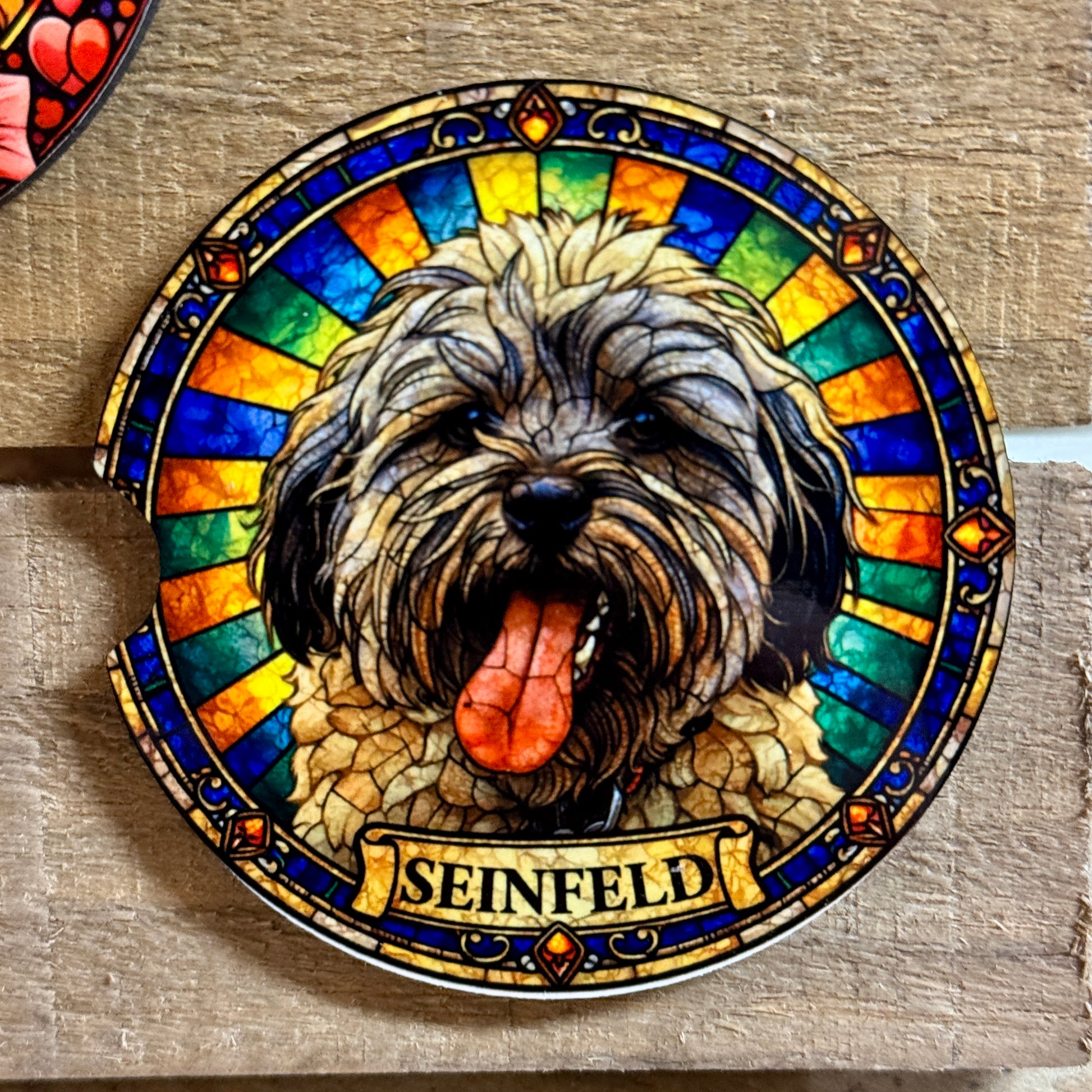 Stained glass-style artwork of a dog with 'Seinfeld' branding on a wooden surface.