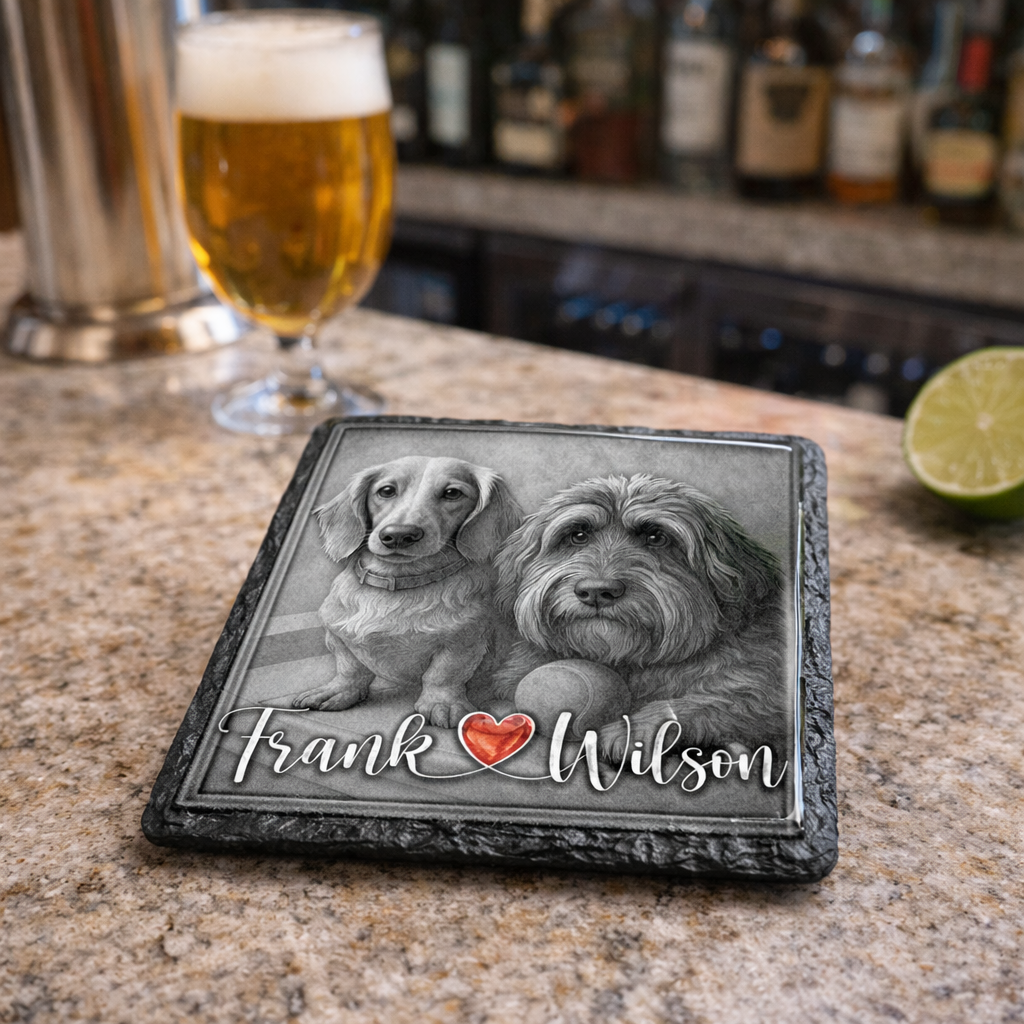 Personalized coaster with two dogs and names on a bar counter with a glass of beer and lime.