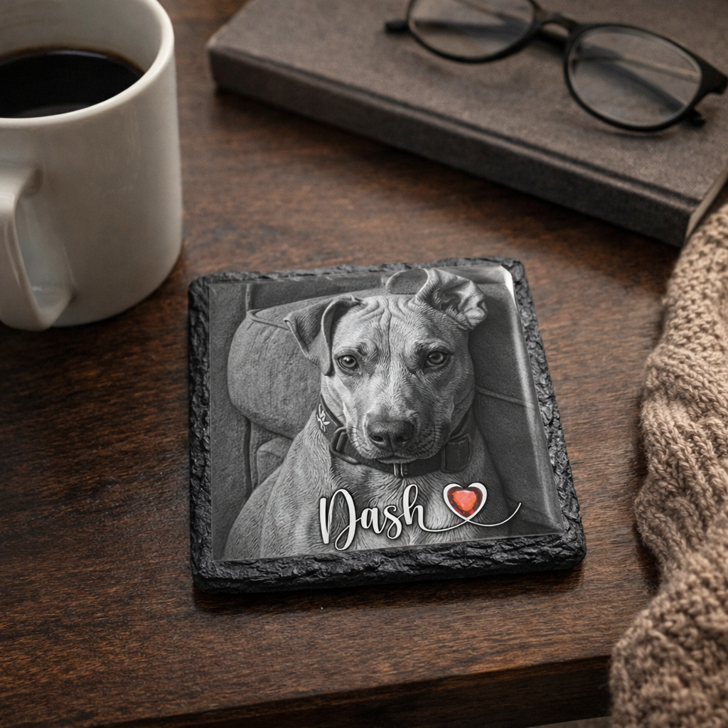 Slate coaster with a dog's photo and name 'Dash' on a wooden table with a mug and glasses.