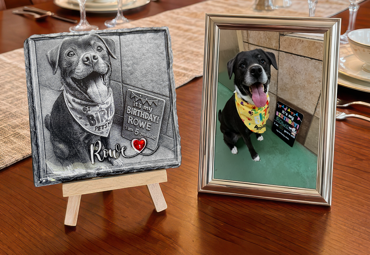Two framed pet portraits on a wooden table