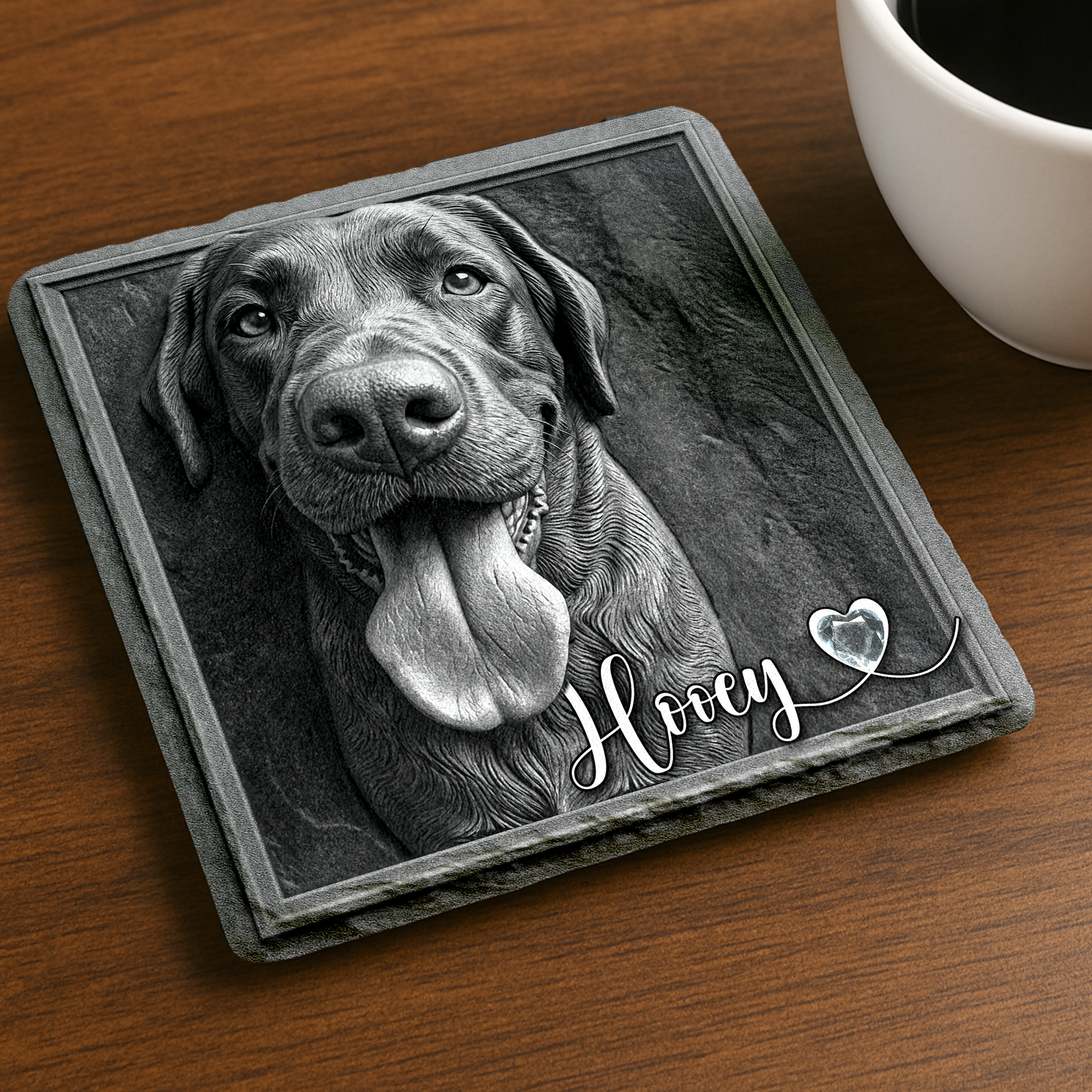 Coaster with a dog's face and 'Hooey' text on a wooden surface with a cup of coffee.