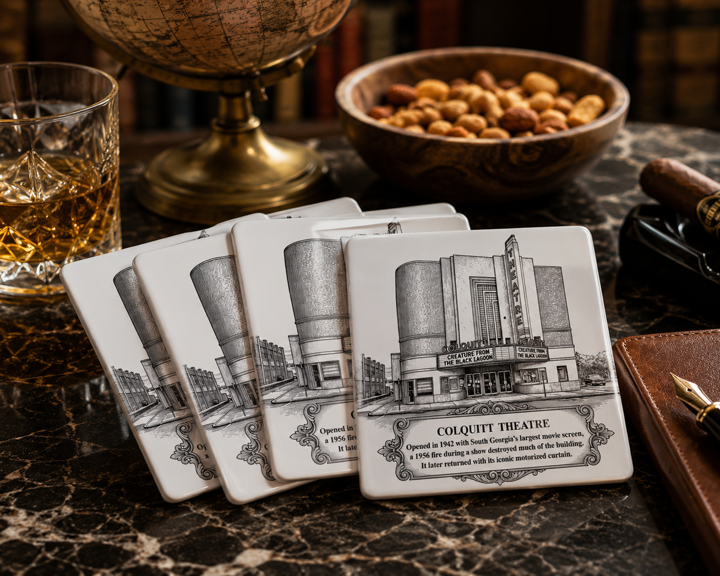 Set of four Colquitt Theatre commemorative ceramic coasters displayed on a marble tabletop in a vintage study, surrounded by a whiskey glass, antique globe, cigar, leather journal, and bowl of mixed nuts.