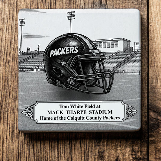 Ceramic drink coaster featuring a detailed black-and-white illustration of a Colquitt County Packers football helmet on Tom White Field at Mack Tharpe Stadium in Moultrie, Georgia.