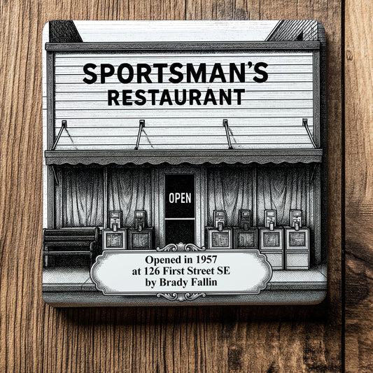 White ceramic coaster with a vintage pen-and-ink engraving of Sportsman's Restaurant in Moultrie, Georgia. Depicts the historic building storefront, an "OPEN" sign, and an ornate timeline text banner, displayed flat on a wood grain background.