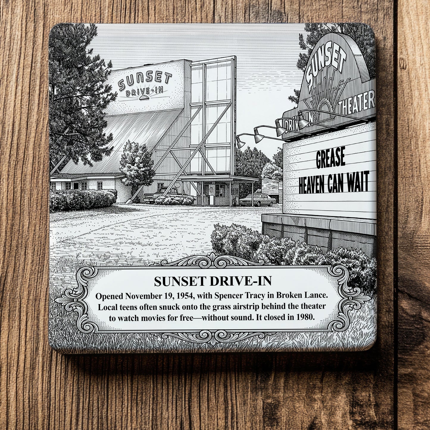 White ceramic coaster with a vintage pen-and-ink engraving of Sunset Drive-In Theater in Moultrie, Georgia. Features the screen tower, a roadside marquee displaying "GREASE," and an ornate historical text banner, flat on a wood grain surface.